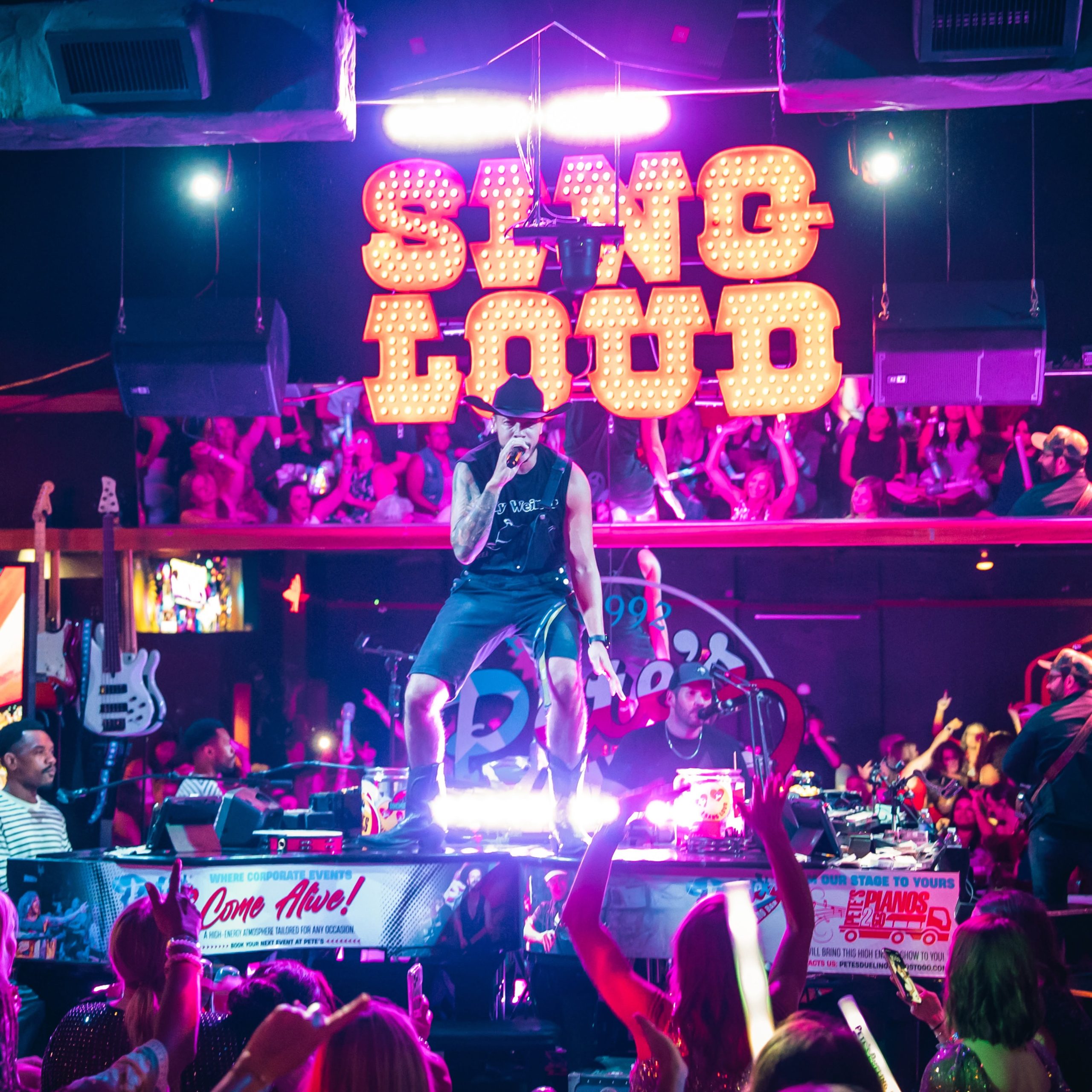 726411759_18324749488262365_6781373627367810376_n image from Pete's Dueling Piano Bar in Downtown Houston Texas - shows musician singing on top of a piano entertaining the crowd.